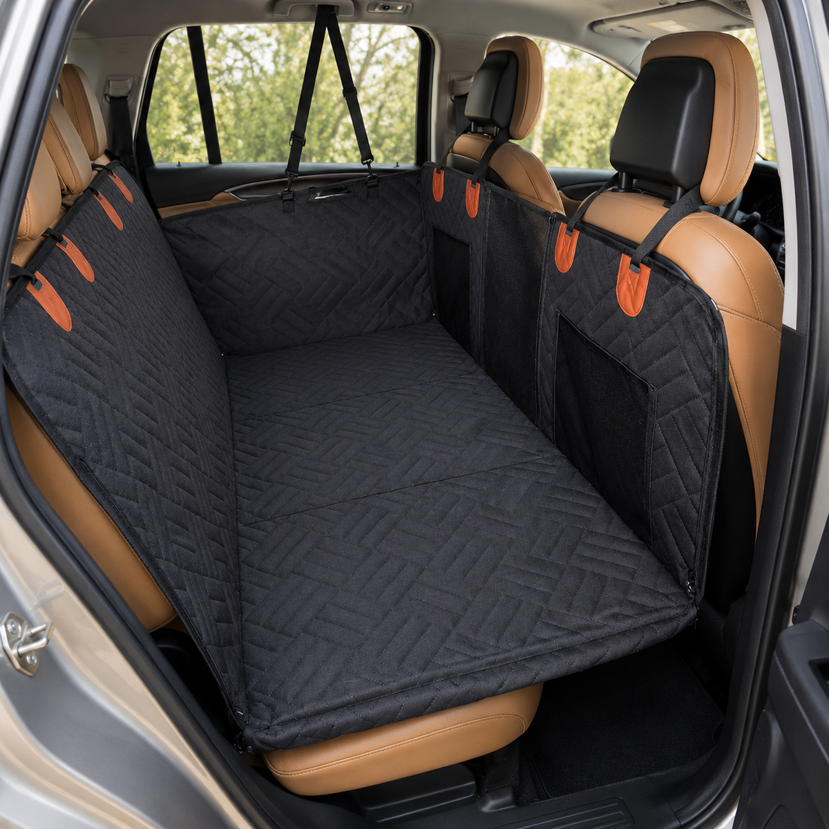 A black dog car seat cover liner with orange accents is shown installed across the rear seats of a vehicle with tan leather seats.